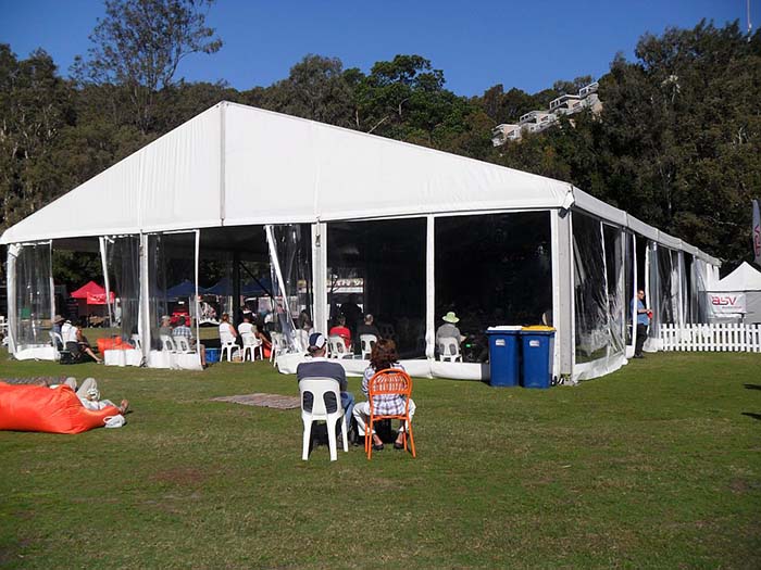 15 x 30m Pavilion Marquee covers a main concert stage with seating for guests under cover. Clear walls provides a view outside at the other festival a